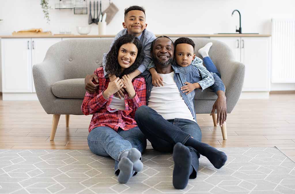 Parents and two kids sitting in front of a couch